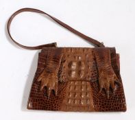 A brown crocodile skin handbag, with claws, gilt metal mounts, suede lined, strap. Purchased on Bond