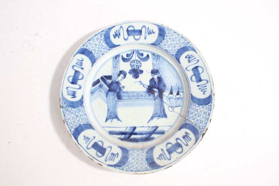18th Century Delft plate, in blue with two Oriental figures in a room and a geometric edge, 23cm