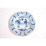 18th Century Delft plate, in blue with two Oriental figures in a room and a geometric edge, 23cm