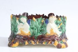 Unusual late 19th century majolica dish, decorated with four putti/cherubs amoungst reeds, 17cm wide