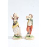 A pair of 19th century figures, baring Derby Marks, one depicting a young boy playing a pipe the