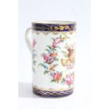 A 19th century French porcelain mug, in the style of Derby, decorated with a floral theme and