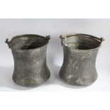 Pair of Middle Eastern metal pots, each with swing handles and floral designs, 27cm tall, 24cm