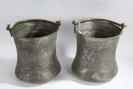 Pair of Middle Eastern metal pots, each with swing handles and floral designs, 27cm tall, 24cm