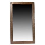 Large Arts & Crafts copper framed mirror, the beaten frame with fleur de lys and rose decoration