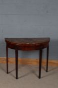 George III mahogany demi lune card table, the top decorated with cross banding, raised on tapering