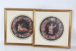 A pair of circular prints depicting cherubs on a black ground with a bouquet of flowers decorating