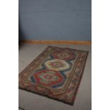 Tibetan style rug, with red blue and cream ground set with three medallions and multiple borders,