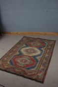 Tibetan style rug, with red blue and cream ground set with three medallions and multiple borders,