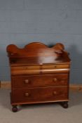 Victorian mahogany dressing chest, with a wavy gallery with two corner shelves above two bombe