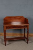 20th century mahogany washstand, with a wooden gallery above two drawers and turned legs joined by a