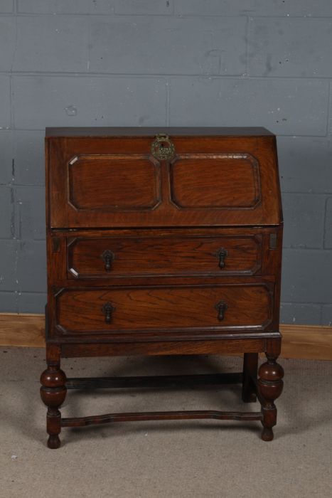 20th century oak bureau, the sloping fall opening to reveal various storage compartments above two