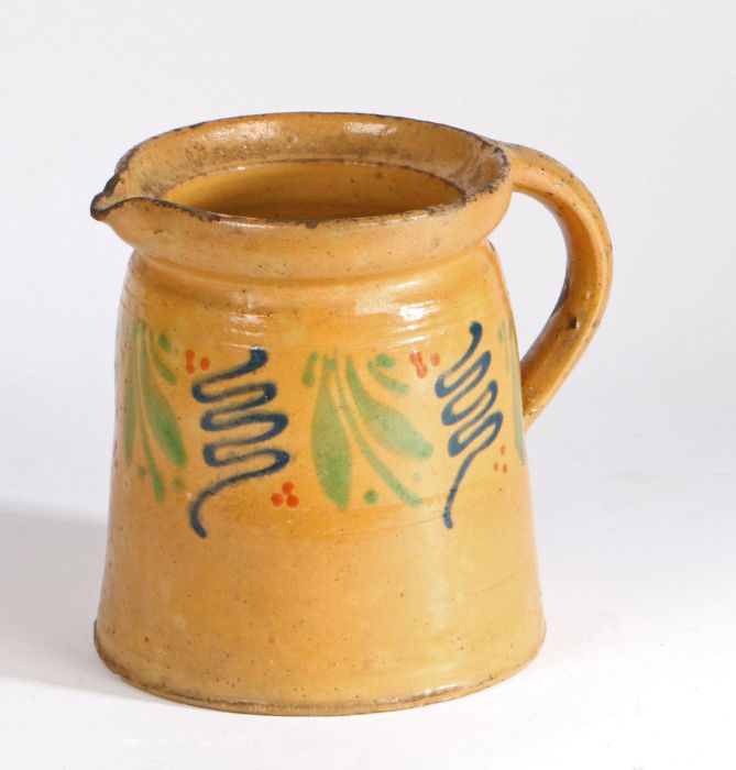 19th Century French slipware jug, with mustard yellow, blue and green decoration, 17cm high