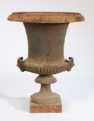 Cast iron campagna form garden urn, the gadrooned lower section with twin goat masks, on a square