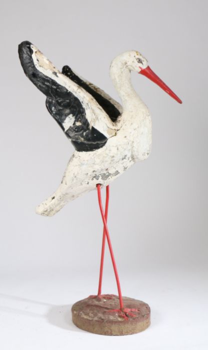 Early 20th Century garden stork, the concrete black and white painted body raised on red legs, 109cm