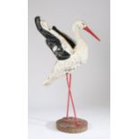 Early 20th Century garden stork, the concrete black and white painted body raised on red legs, 109cm