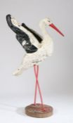 Early 20th Century garden stork, the concrete black and white painted body raised on red legs, 109cm