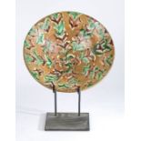 19th Century slipware charger or bowl, in browns, creams and green, restored, 29.5cm wide