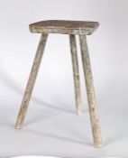 Primitive 20th Century stool, with a trapezium shaped seat above three chamfered legs, with remnants