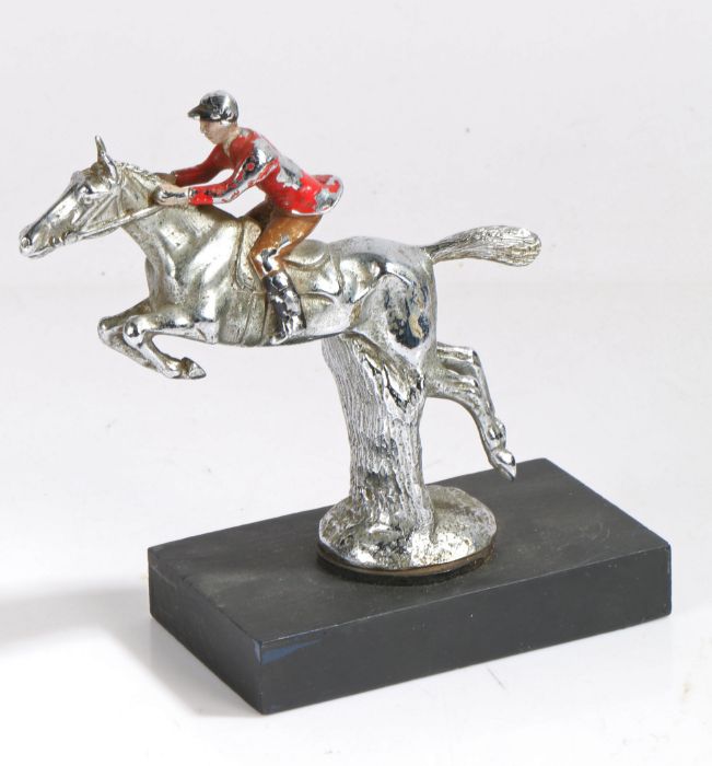 Chrome car mascot, in the form of a horse and rider, with rider with red jacket, on black painted