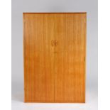 Teak two door wardrobe, the pair of doors enclosing shelves and a hanging rail, 131cm high, 89cm