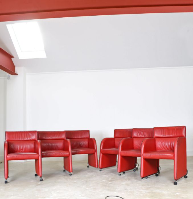 A set of six Swedish red leather armchairs, by Kinnarps, crca 1988, raised on chromed supports to