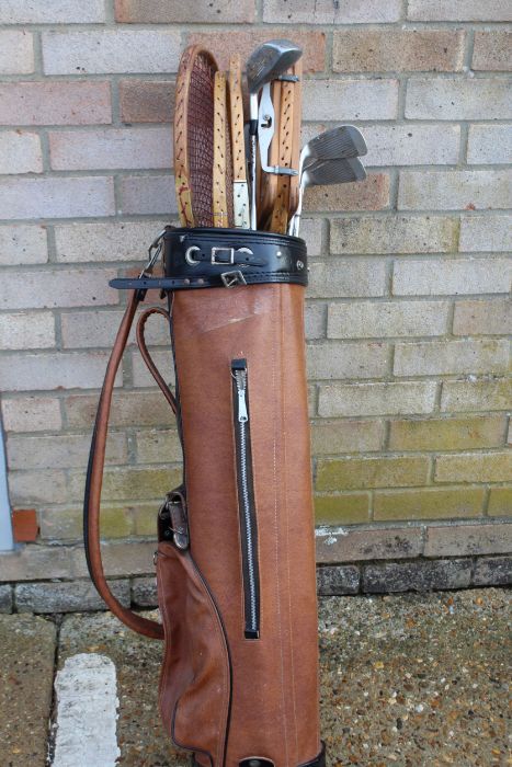 Brown leather golf bag, with a part set of golf clubs and four wooden tennis rackets