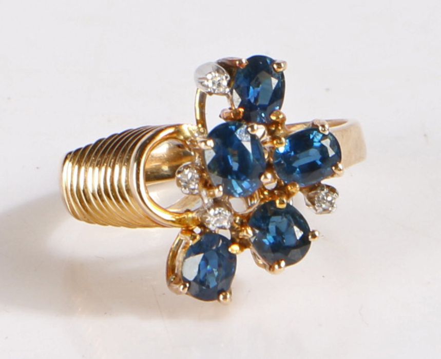 14 carat gold and diamond ring, the head set with five claw mounted blue stones and four diamonds,