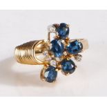14 carat gold and diamond ring, the head set with five claw mounted blue stones and four diamonds,