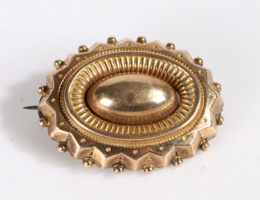 Yellow metal brooch, set with a central oval design with ball decoration, unmarked, weight 5.7 grams