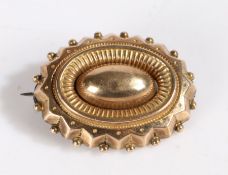 Yellow metal brooch, set with a central oval design with ball decoration, unmarked, weight 5.7 grams