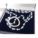 A long multi-layer pearl necklace, comprised of cultured alternating dyed and white pearl, measuring