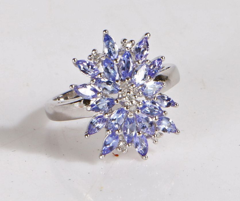 Silver and tanzanite cluster ring, the head set with many claw mounted tanzanite stones, gross