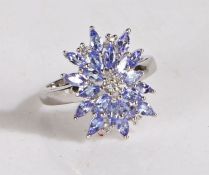 Silver and tanzanite cluster ring, the head set with many claw mounted tanzanite stones, gross