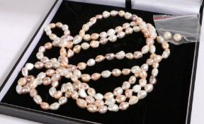 An elegant long multi-layer pearl necklace and pearl earrings, the necklace comprised of alternating