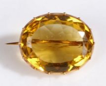 A 9 carat gold and yellow stone set brooch, of oval form and facetted edge, 23 x 19mm, 6.20 grams.