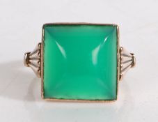 A yellow metal ring with a green emerald cushion cut stone to the centre and with geometric fan