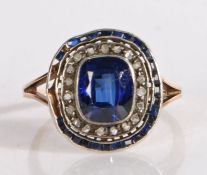 Sapphire and diamond ring, the central step cut sapphire surrounded by a band of diamonds and