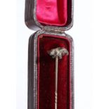 An elegant stick pin with twist detailing, surmounted by a stalking bear, weight 1.77 grams.