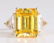 14 carat gold ring having a large emerald cut yellow stone to the centre with trillion cut white