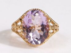 A 9 carat gold gem-set ring, featuring a pretty large oval cut pinkish-purple gem mounted on a