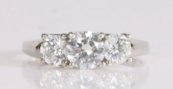 A platinum three stone ring, having three round cut cubic zirconias mounted in a criss-crossed
