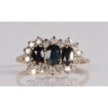 9 carat gold and gem set cluster ring, having three graduated oval cut stones to the centre