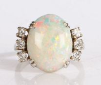 Opal and diamond ring, the central oval opal flanked by three diamonds to each shoulder, on a