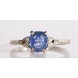 An 18 carat white gold sapphire and diamond ring, having a central emerald cut sapphire with diamond