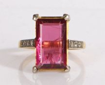 18 carat gold ring set with a central rectangular faceted purple stone, with three diamond chips