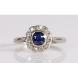 A sapphire and diamond cluster ring, the oval cut sapphire is bezel set, surrounded by old brilliant