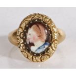 An enamel ring, the oval enamel head depicting a lady in profile with a yellow metal band, 4.4