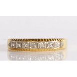 18 carat gold and diamond eternity ring, having a line of nine millegrain set diamonds in a white