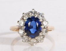 9 carat gold ring set with a central oval blue paste stone and surrounded by a band of clear